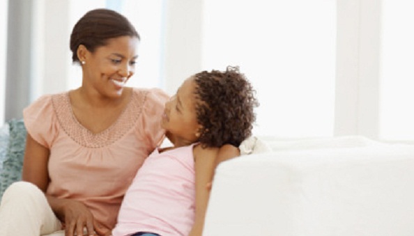 African American mother and daughter talking together with copyspace at home
