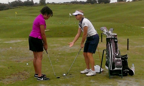Ronnie taking golf instruction from Charlotta.