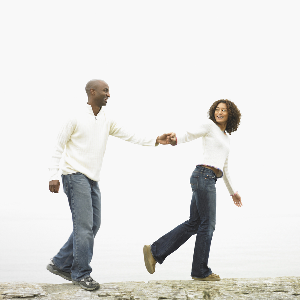 helping your spouse grow spiritually black african american couple man woman in white shirt blue jeans Couple Hands Walk Pull
