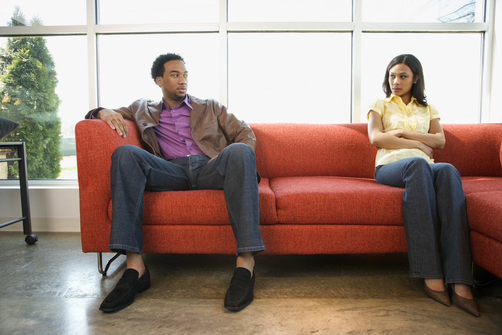 staying together after infidelity couple mad at each other distance on couch black man and woman